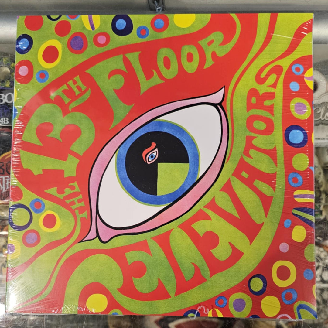 Colorful album cover with eye design and text on a reflective surface