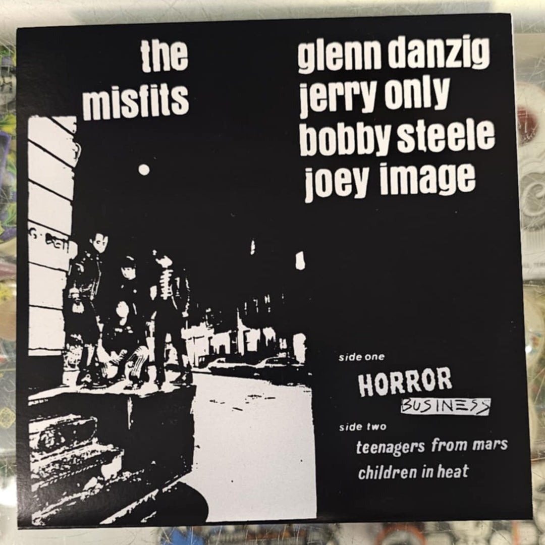 Vinyl record cover with text and black and white image of people in a room, on a store shelf.