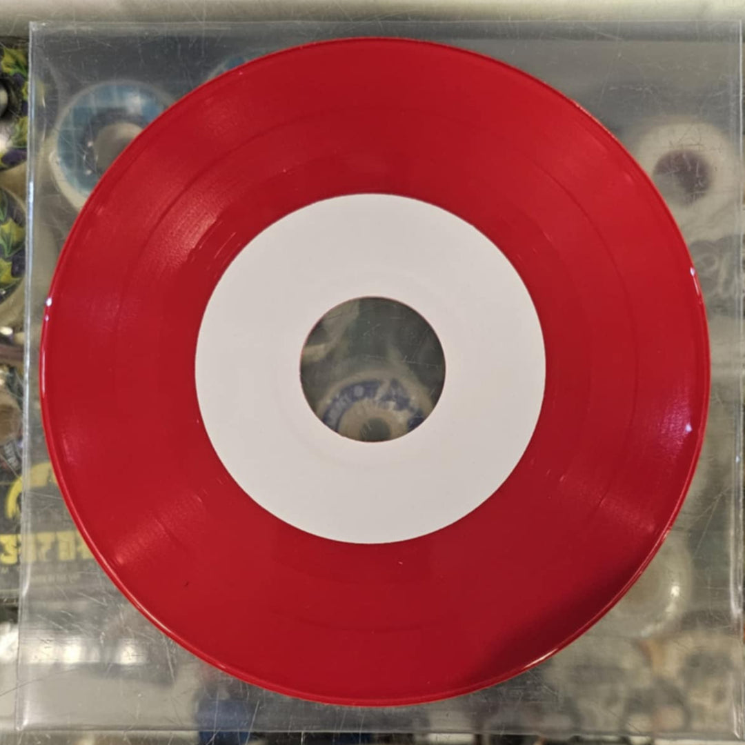 Red vinyl record with white center on a clear plastic sleeve against a colorful background.