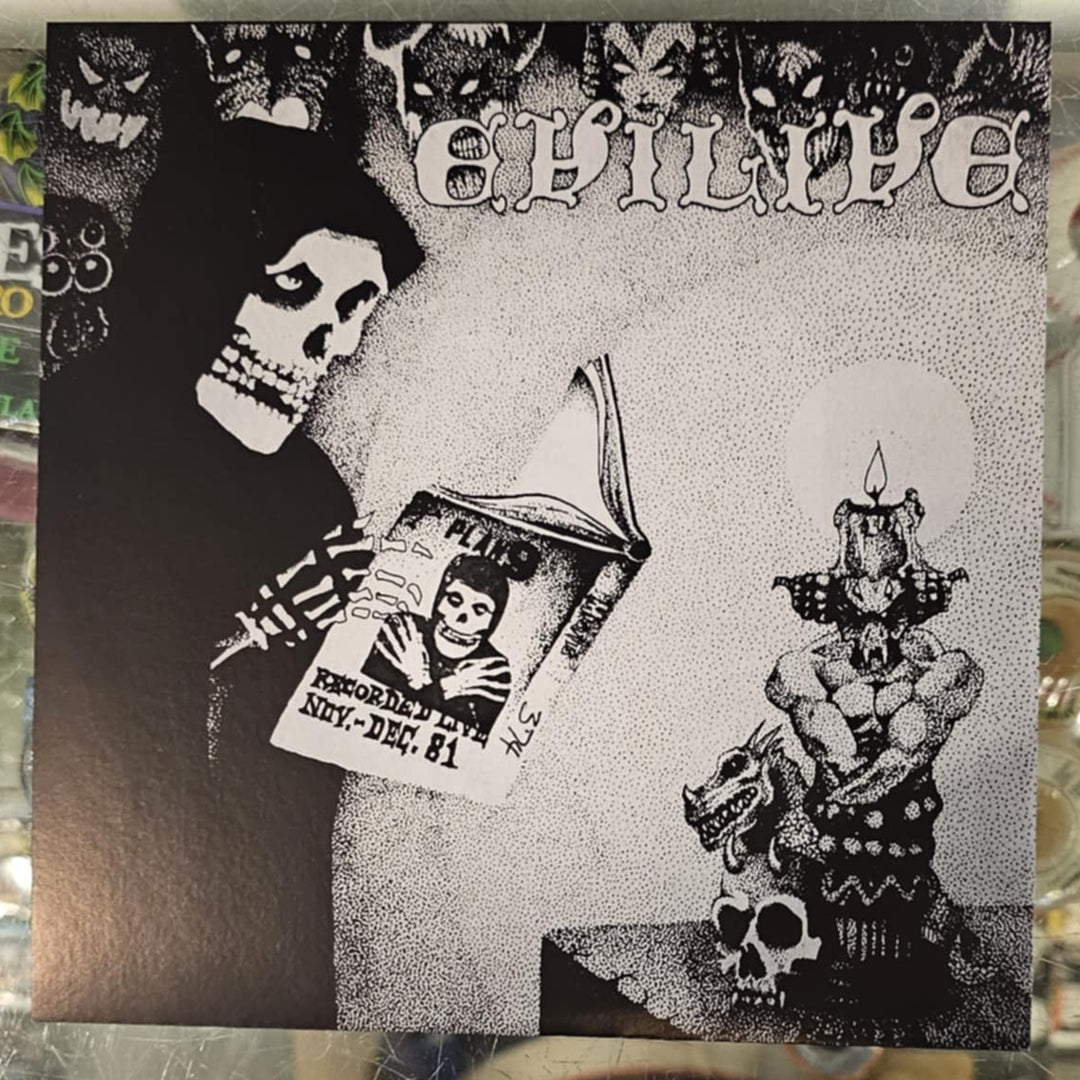 Close-up of a book with black and white illustrations on a reflective surface.