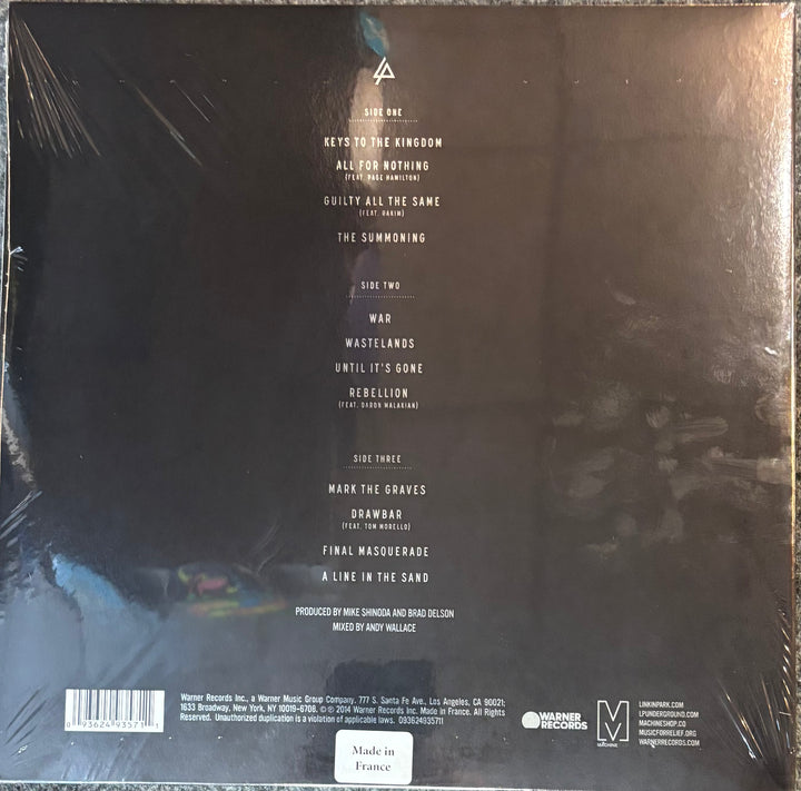 The back cover of a vinyl record sleeve for the album Linkin Park - Hunting Party, wrapped in plastic. The cover is predominantly black with white text listing the tracks and credits, and a small multicolor abstract graphic in the bottom-left corner.
