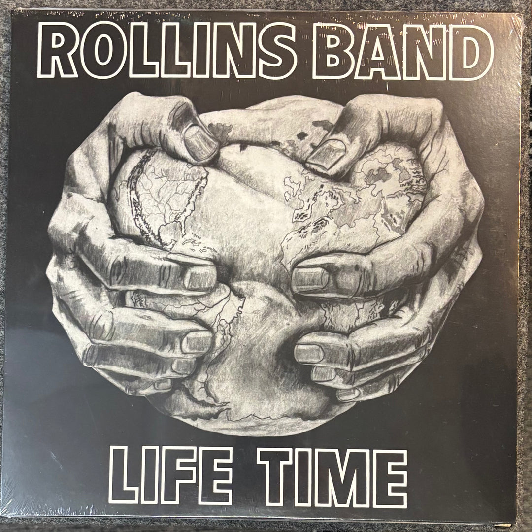Album cover for 'Life Time' by Rollins Band featuring hands holding a cracked egg.