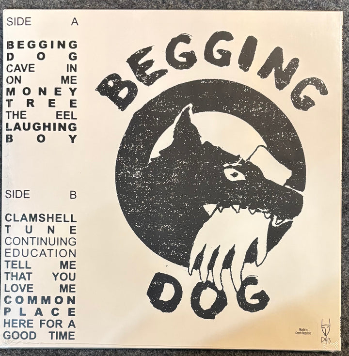 A vinyl record sleeve for the band Begging Dog, featuring a distressed black graphic of a dog's head with a cross over its eyes on a cream-colored background. The left side lists track listings for Side A and Side B in black text.