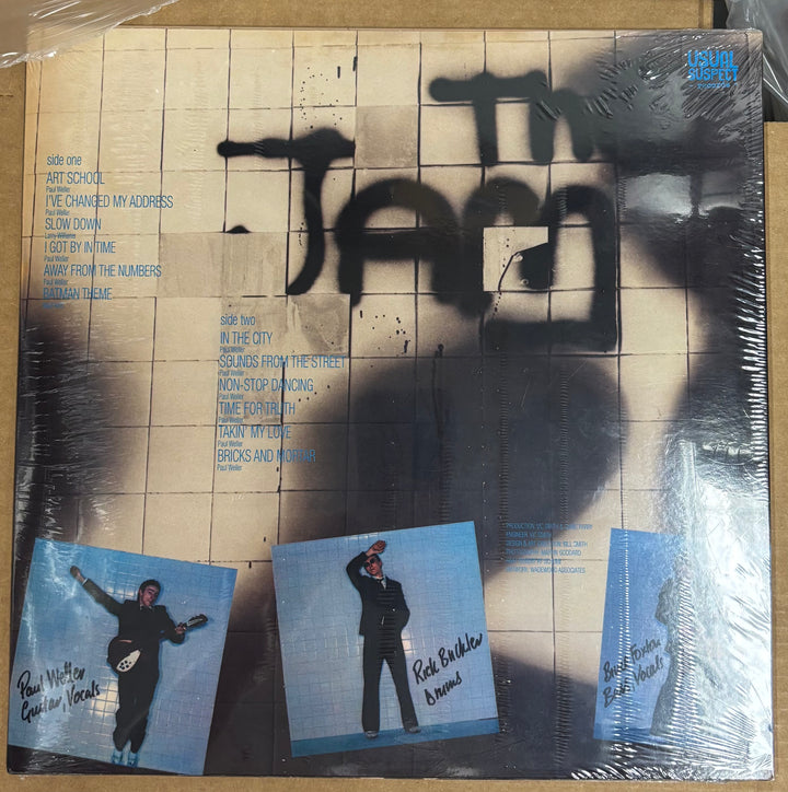 Vinyl record cover with text and images of a person on a tiled background