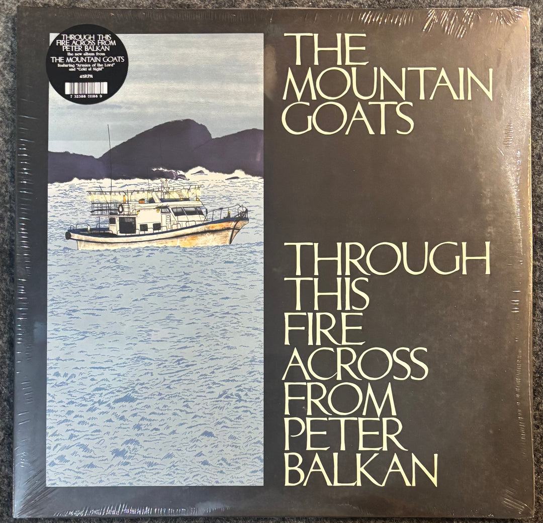 Vinyl record album cover for Peter Balkan's 'The Mountain Goats - Through This Fire Across From', sealed in plastic with a black sticker label in the top left corner.