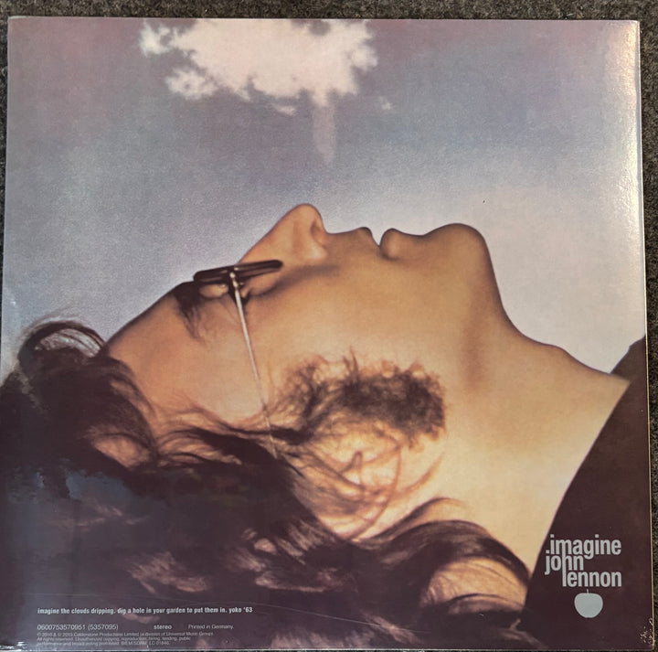 Vinyl record cover for John Lennon's 'Imagine', showing a close-up of the artist's face with sunglasses on a blue sky background, with the album title and artist name printed in the lower right.