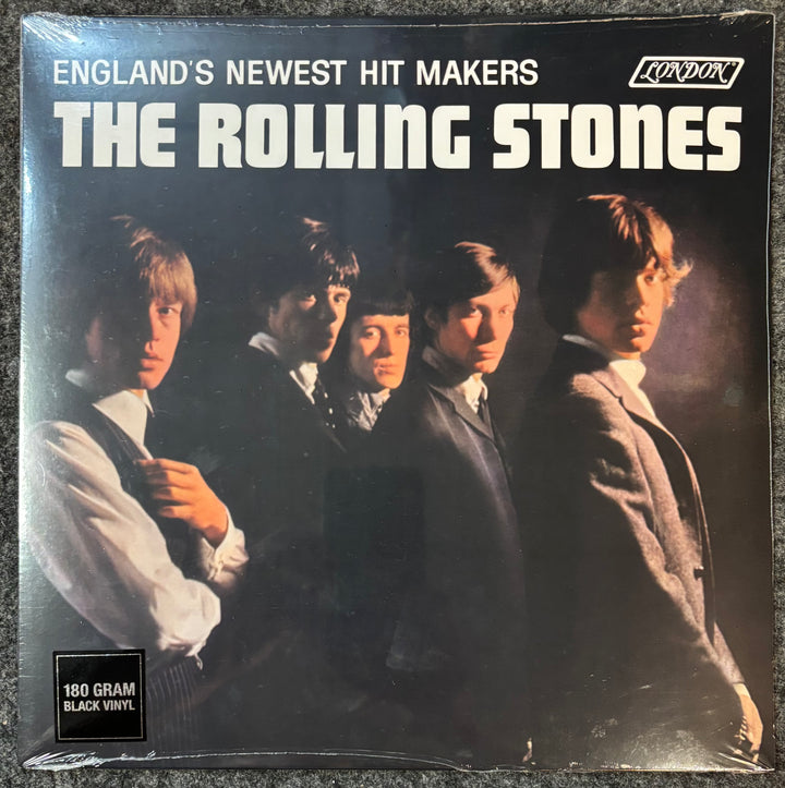 Album cover of The Rolling Stones with band members and text 'England's Newest Hit Makers' on a black background.