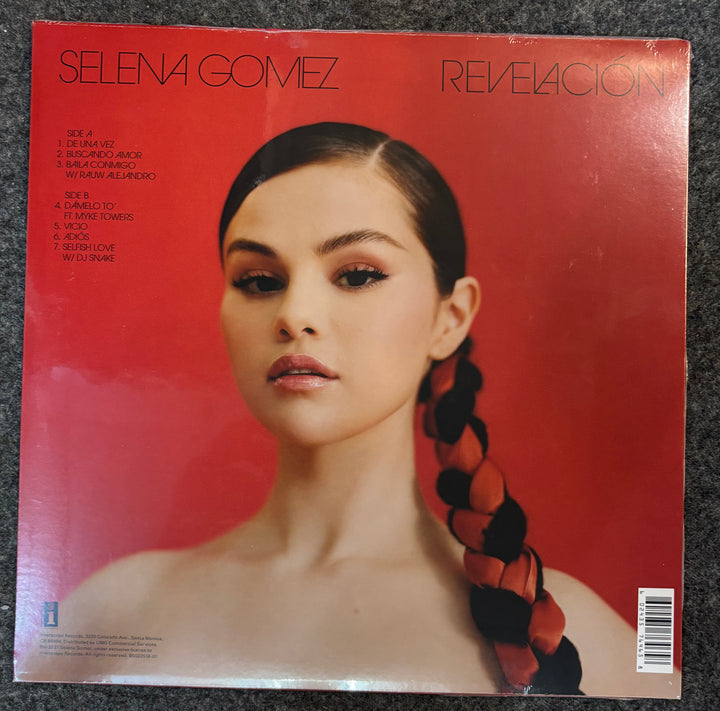 Album cover of 'Revelación' by Selena Gomez with a red background and braided hair.