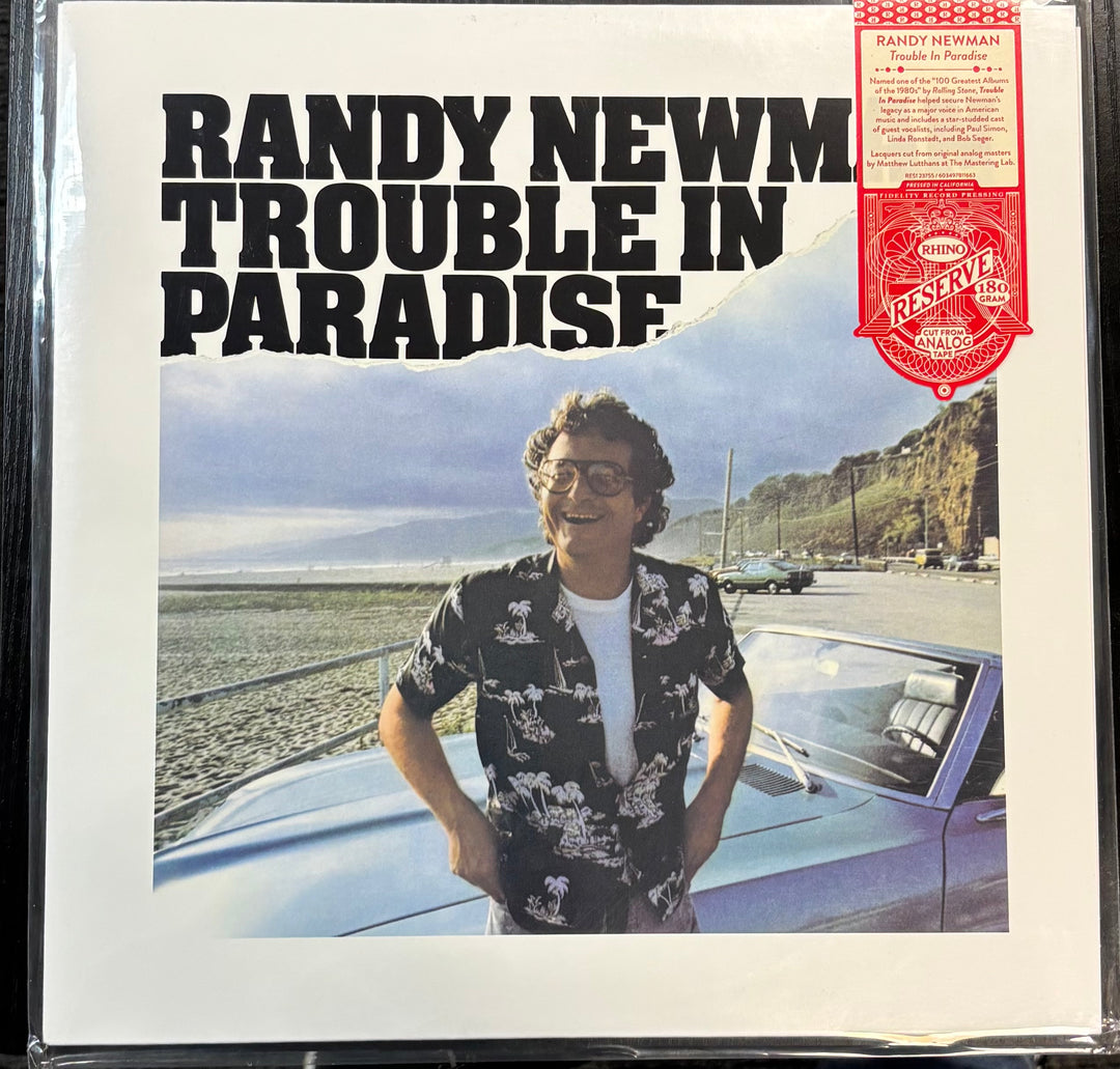 Album cover of 'Trouble in Paradise' by Randy Newman with a person standing next to a car.
