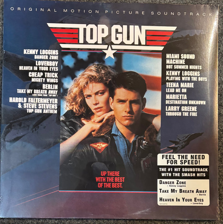 Top Gun Original Motion Picture Soundtrack vinyl record cover, featuring a black background with red and white text, a star emblem, and artwork of a woman and man in fighter jets.