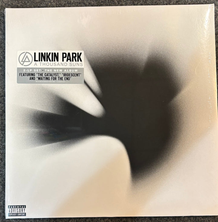 Linkin Park - A Thousand Suns vinyl record album cover, sealed in its plastic shrink wrap, photographed flat on a dark textured surface.