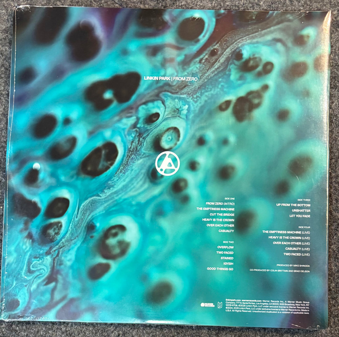 The back cover of a vinyl record for Linkin Park - From Zero, featuring a vibrant turquoise, teal, and black marbled abstract design with track listings on the right side.
