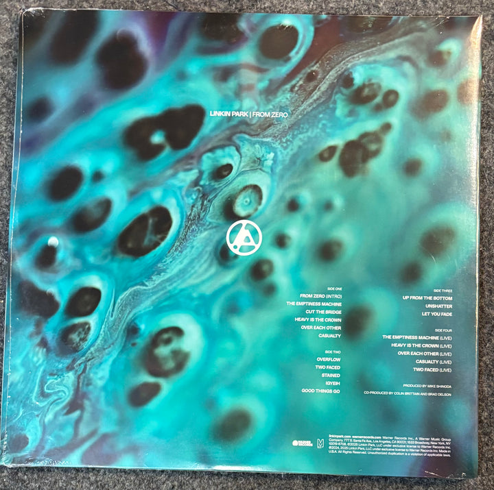 The back cover of a vinyl record for Linkin Park - From Zero, featuring a vibrant turquoise, teal, and black marbled abstract design with track listings on the right side.