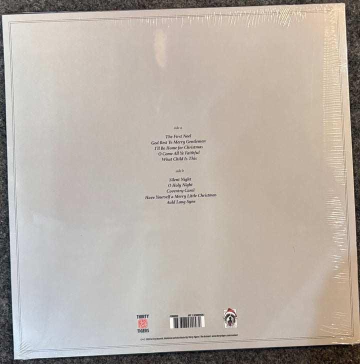 The back cover of a Milk Carton Kids - Christmas In A Minor Key wrapped in clear plastic, showing track listings and a barcode on a white background.