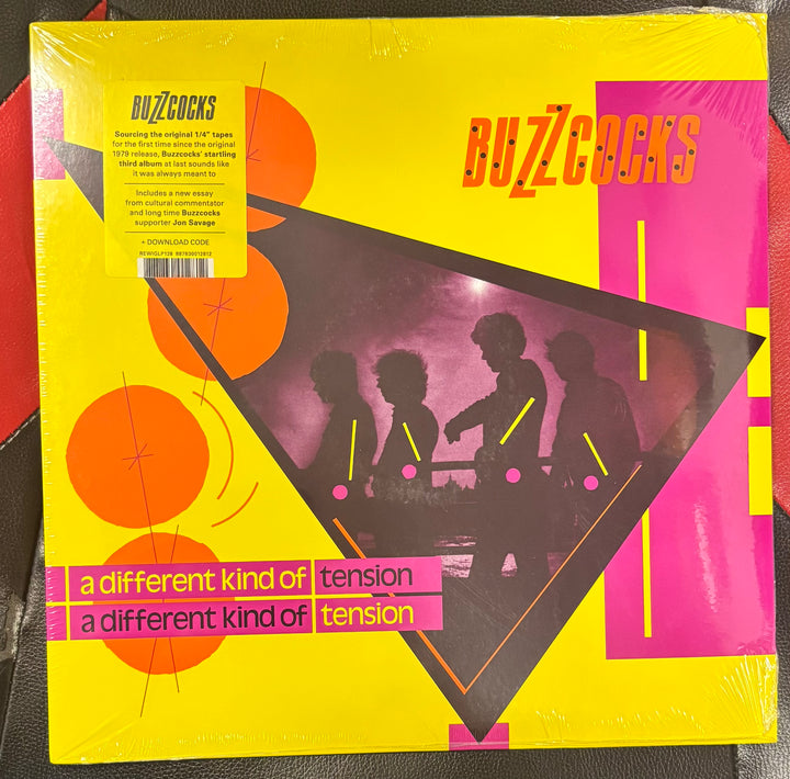 BUZZCOCKS - A Different Kind Of Tension Vinyl record cover with 'Buzzcocks' and 'a different kind of tension' text on a yellow background.
