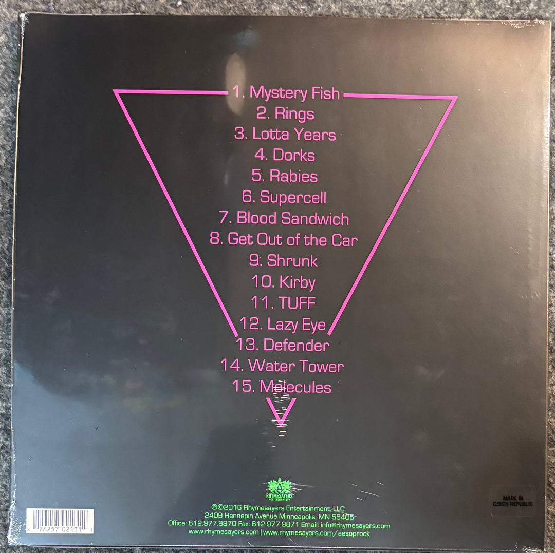 The back cover of Aesop Rock – The Impossible Kid, featuring the tracklist in pink text inside a large pink inverted triangle on a black background.