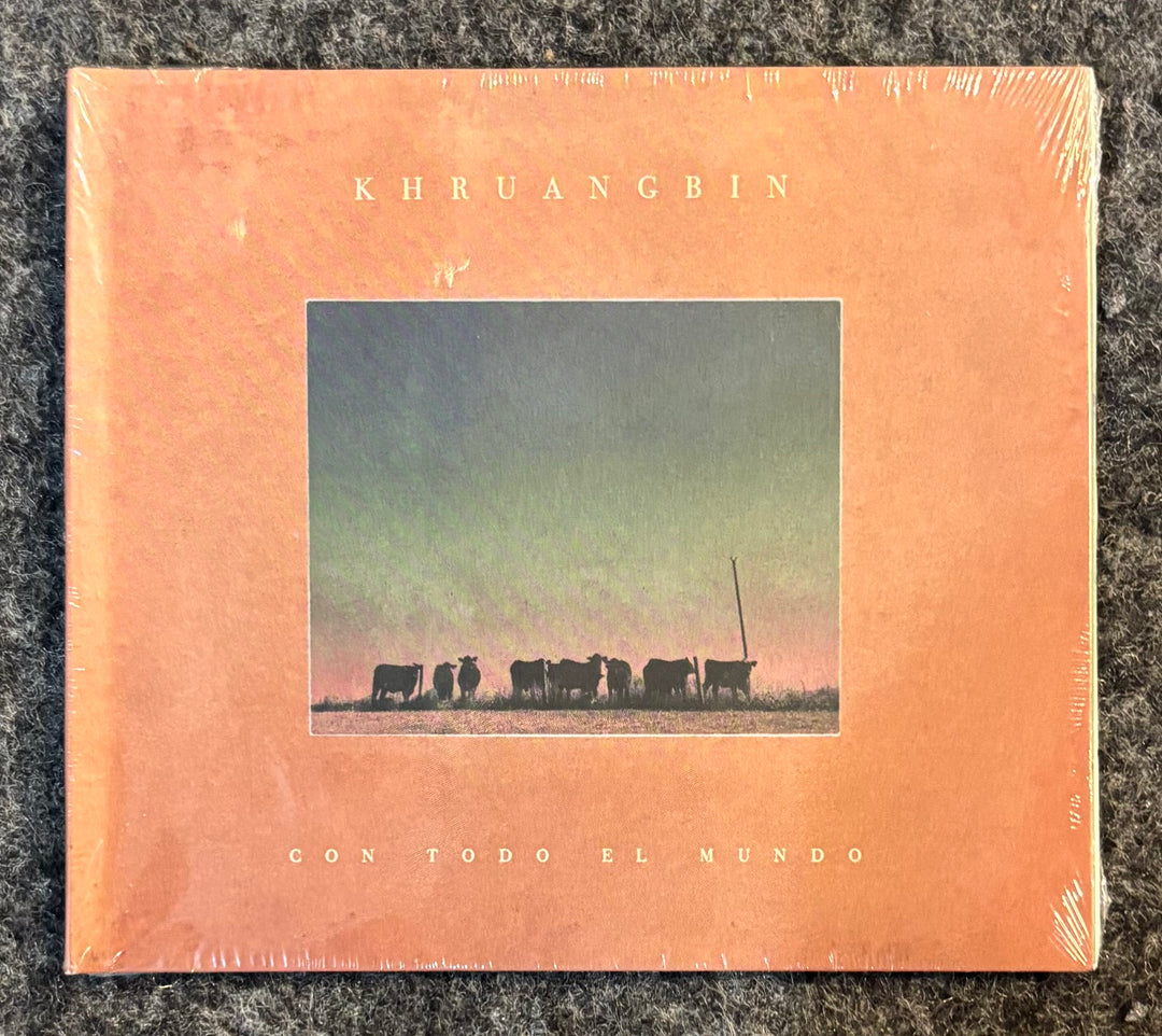 Album cover of Khruangbin's 'Con Todo El Mundo' with a silhouette of cows on a peach background.
