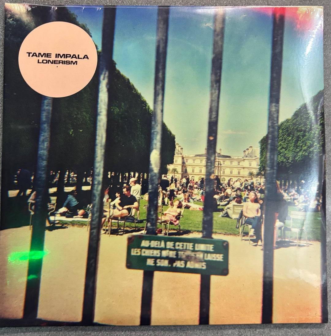 Vinyl record cover for Tame Impala's 'Lonerism' with a park scene through bars.