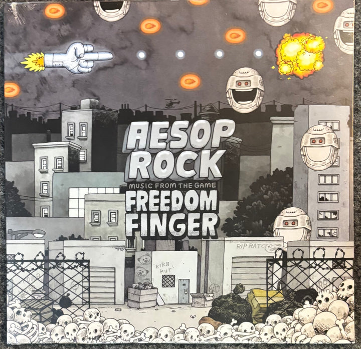Square album or game cover art for 'Freedom Finger' featuring a dark, illustrated city scene with buildings, skulls, robots, explosions, and the title text 'Aesop Rock Music from the Game Freedom Finger' in large white letters.