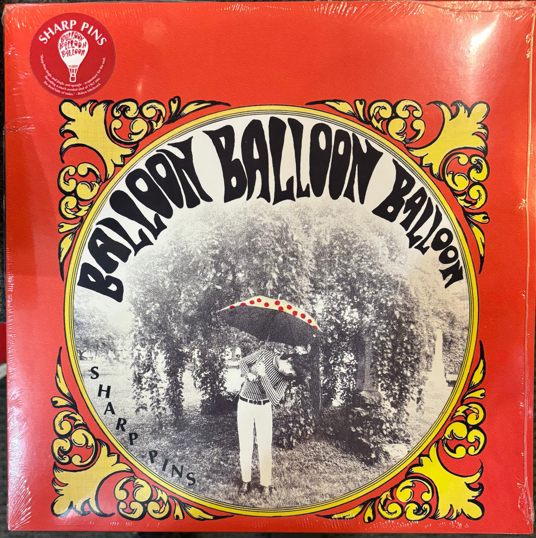 A vinyl record cover for Sharp Pins ‎– Balloon Balloon Balloon, featuring a bright red background with yellow and gold ornate scrollwork and a central circular black-and-white photograph of a person holding a red-and-white balloon.