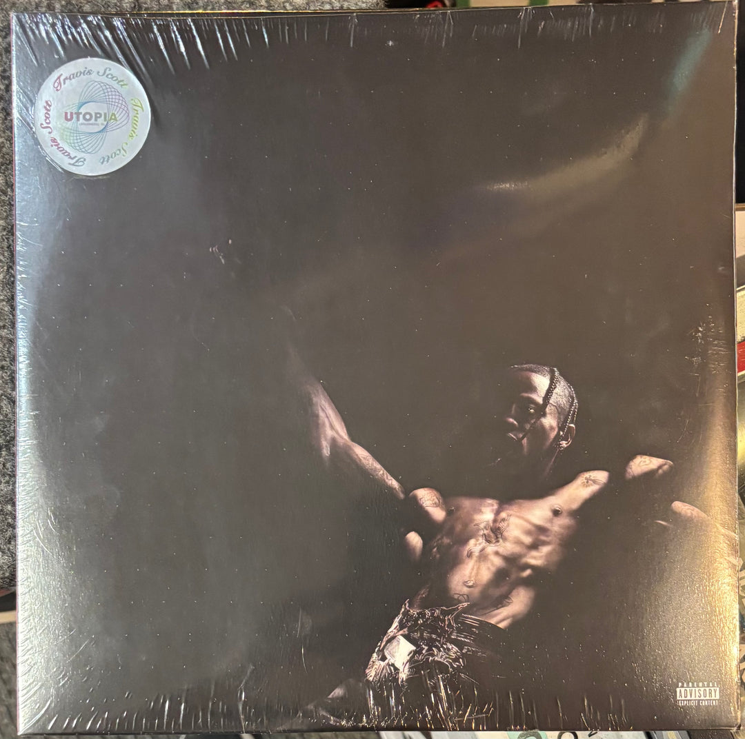 Travis Scott – Utopia record with a person holding a gun on the cover, featuring a 'UTOPIA' label.