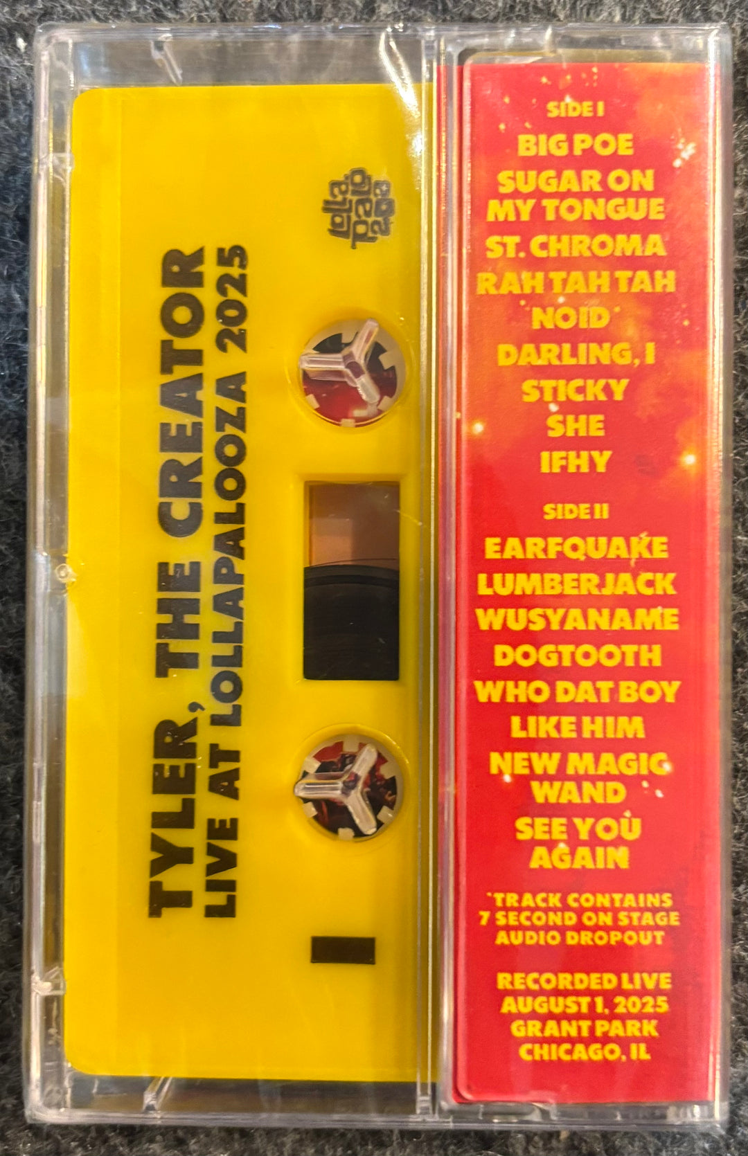 TYLER, THE CREATOR - LIVE AT LOLLAPALOOZA Cassette tape with yellow label and red text on a black background
