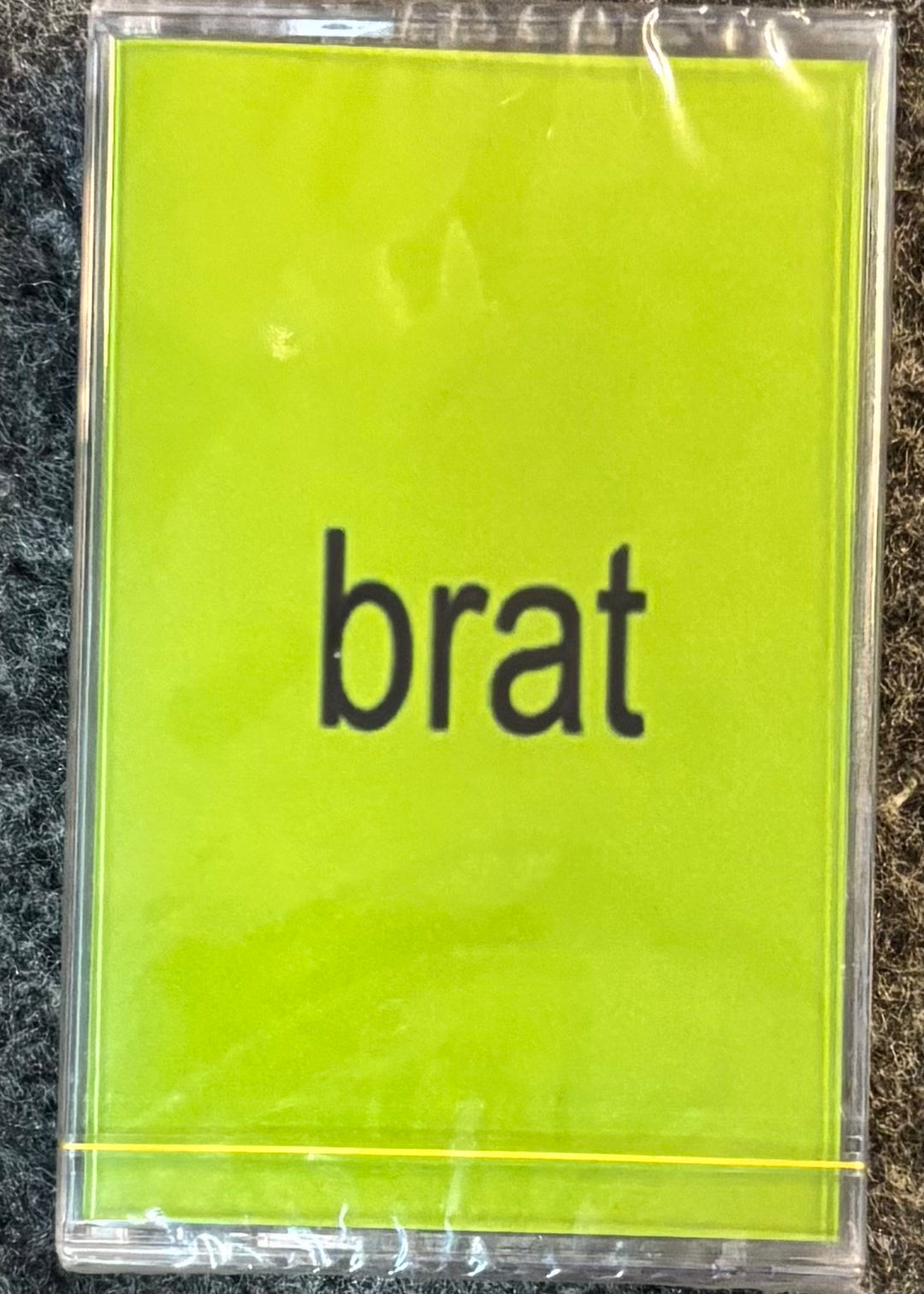 CHARLIE XCX - BRAT tape with 'brat' text on a yellow background