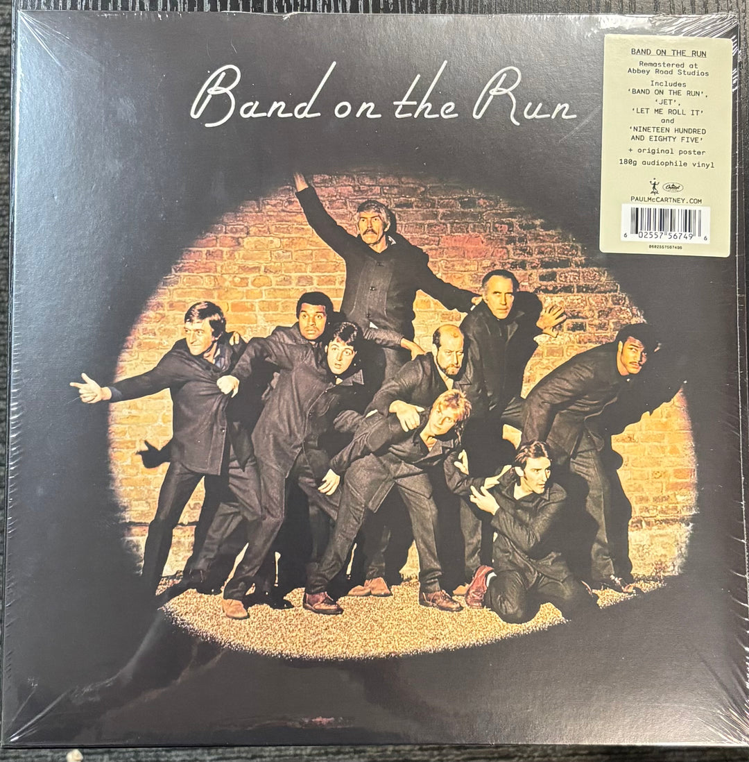 Album cover of 'Band on the Run' featuring a group of people in front of a brick wall.