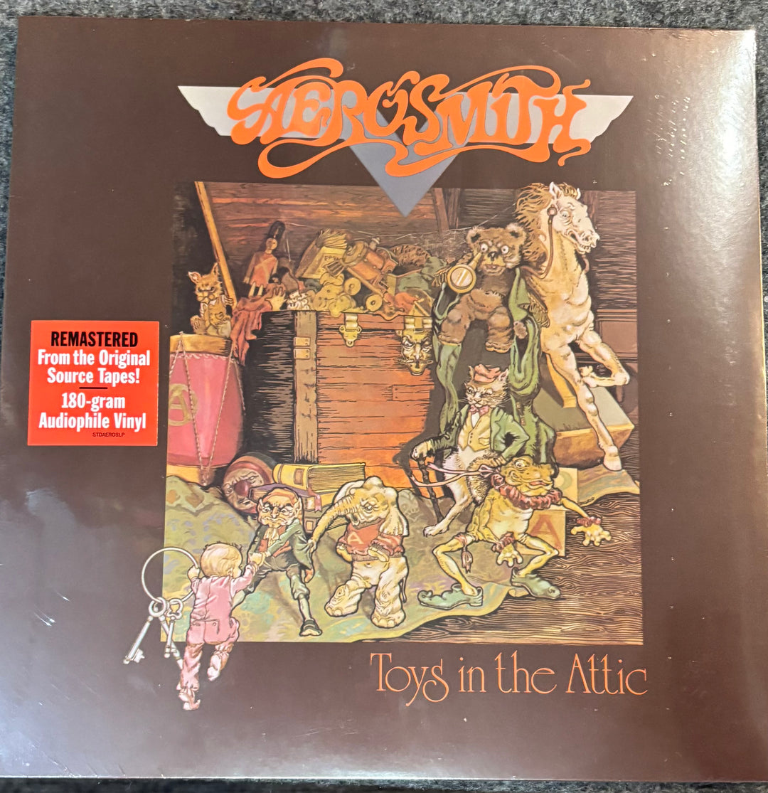 Vinyl record cover for Aerosmith's 'Toys in the Attic' with colorful illustration and text.