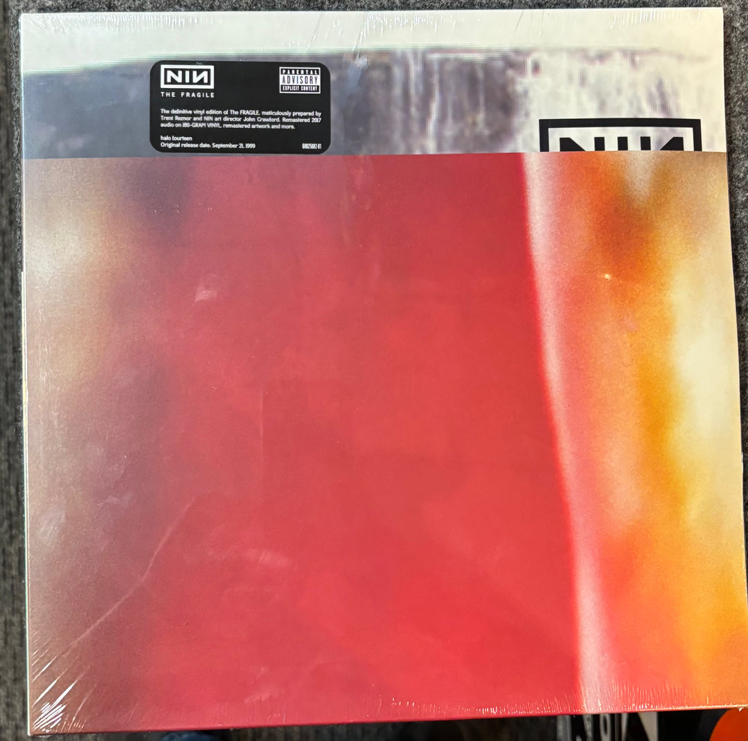 Nine Inch Nails – The Fragile  record with a colorful cover featuring red, orange, and black colors.