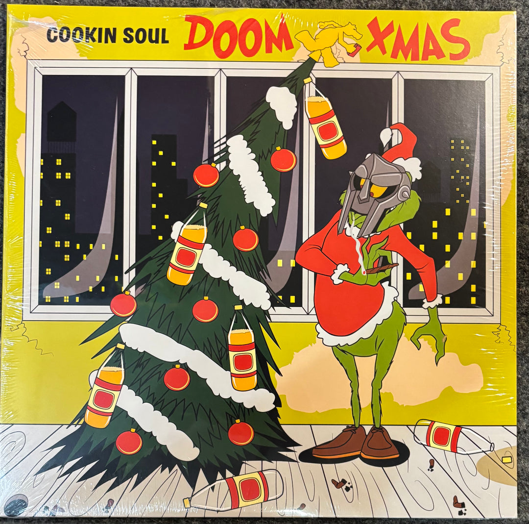 MF DOOM x COOKIN SOUL - Doom X-Mas cover with a cartoon character in a Santa suit next to a Christmas tree, with text 'Cookin Soul Doom Xmas'.