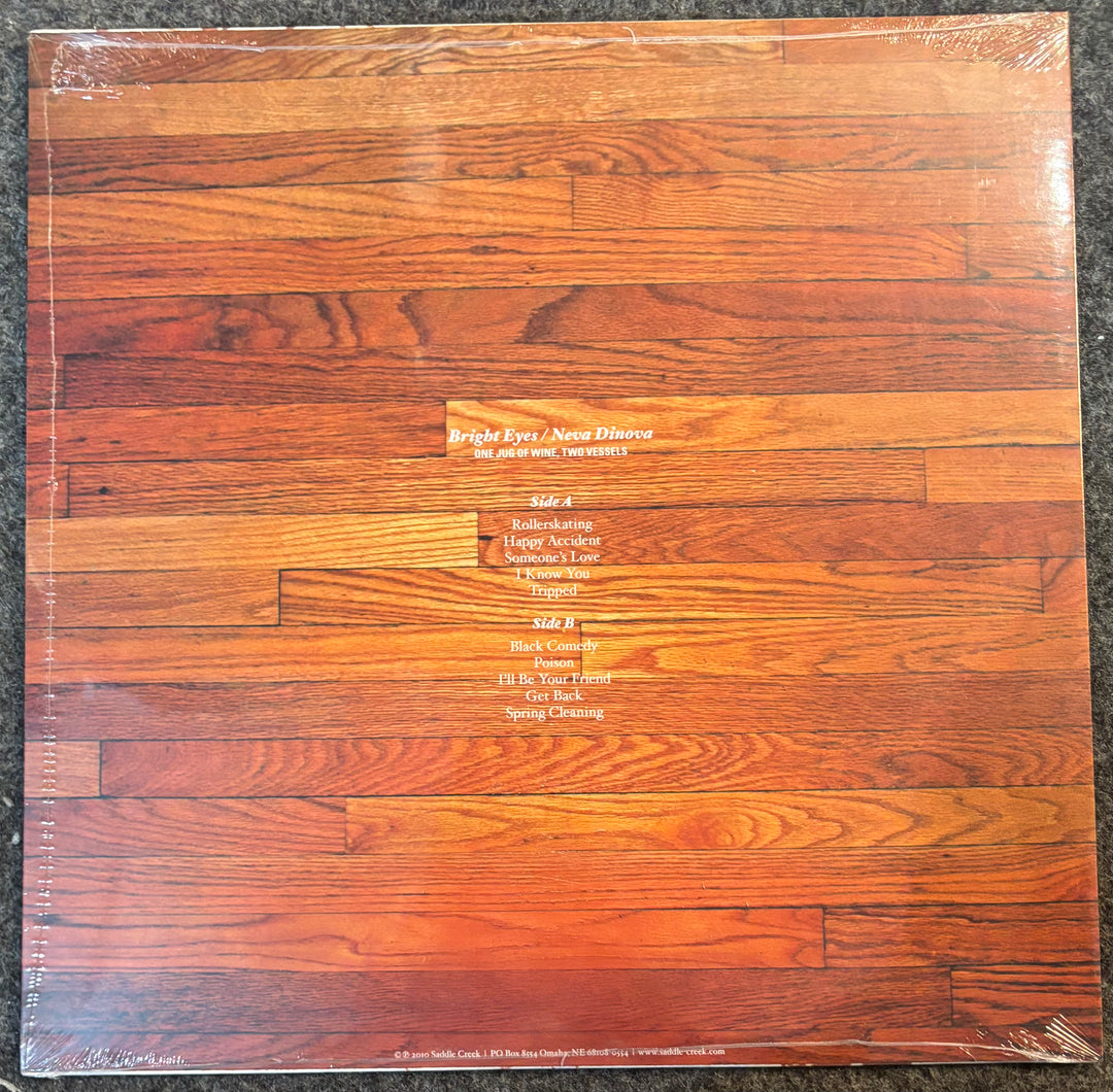 Bright Eyes/Neva Dinova - One Jug of Wine, Two Vessels record with wooden panel design and text on a dark surface