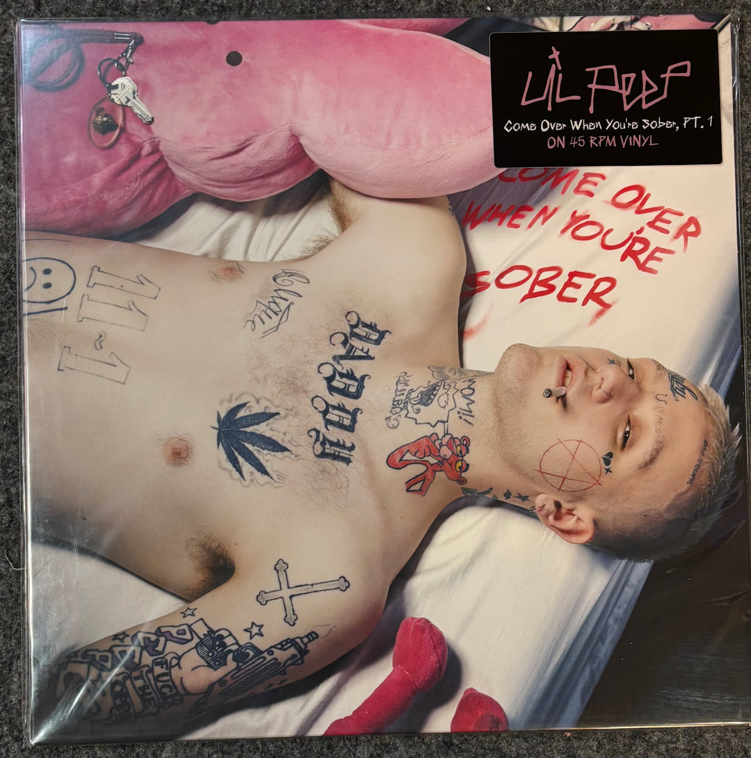 Lil Peep - Come Over When You're Sober Part 1 vinyl record cover, featuring a shirtless tattooed man lying on a bed with a pink plush toy, a black artist label, and red handwritten text.