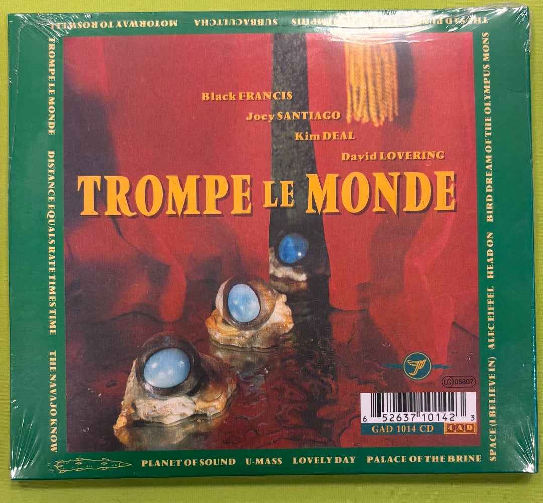 Album cover of 'Trompe Le Monde' by Black Francis featuring a red background and stone-like objects with blue stones.