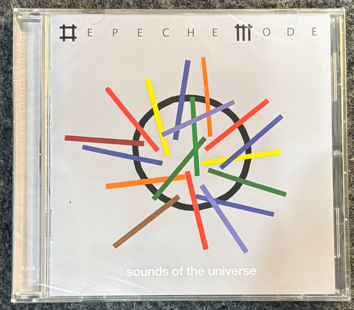 CD cover of 'Sounds of the Universe' by Depeche Mode on a gray surface