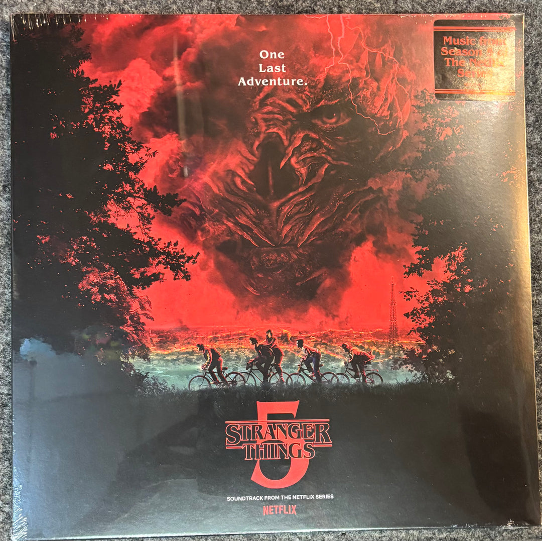 Vinyl record cover for 'Stranger Things' with a red and black design featuring a creature and people on bicycles.