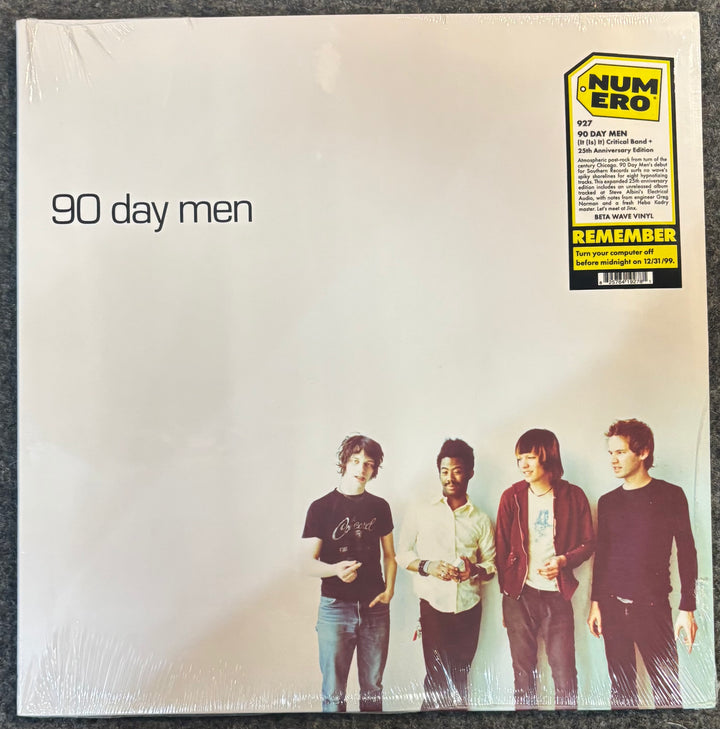 The front cover of 90 Day Men - (It (Is) It) Critical Band + (Y2K 25th Anniversary Edition), sealed in plastic shrink wrap. The cover is off-white with the band members' photo at the bottom and a yellow/black Numero sticker in the top right corner.