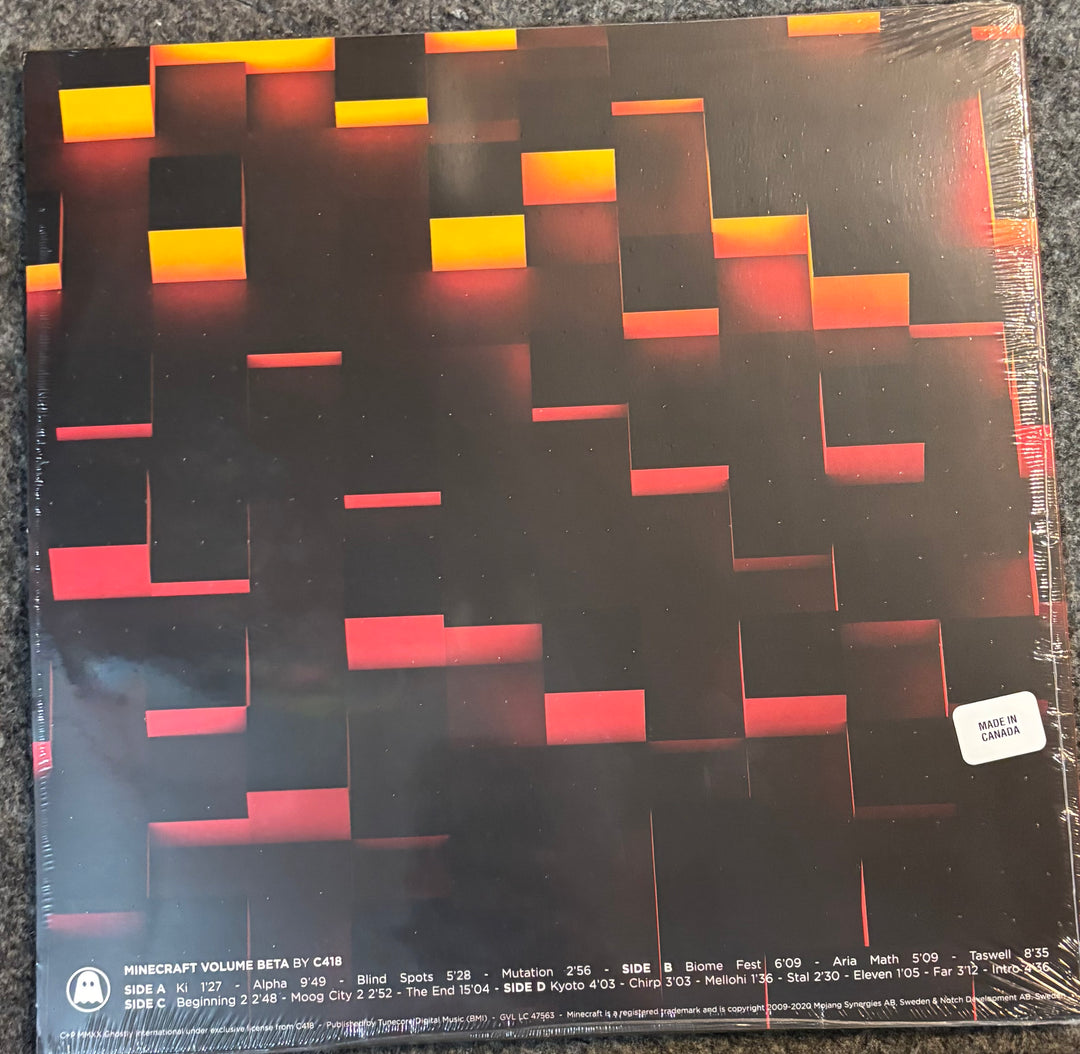 A vinyl record sleeve for 'Minecraft Volume Beta' by C418, featuring a 3D block pattern in black, red, and orange. The sleeve is sealed in plastic shrink wrap and photographed on a dark textured carpet.