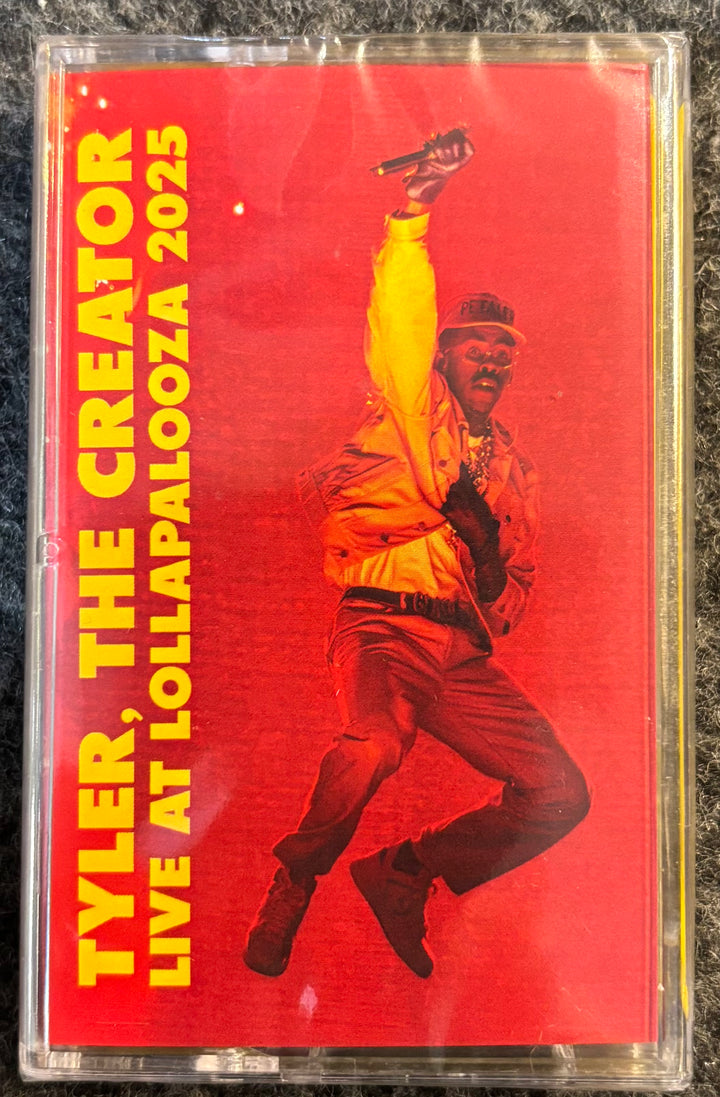 TYLER, THE CREATOR - LIVE AT LOLLAPALOOZA Cassette tape cover with a person in a yellow jacket and red background, featuring text about Tyler, The Creator and Lollapalooza 2025.