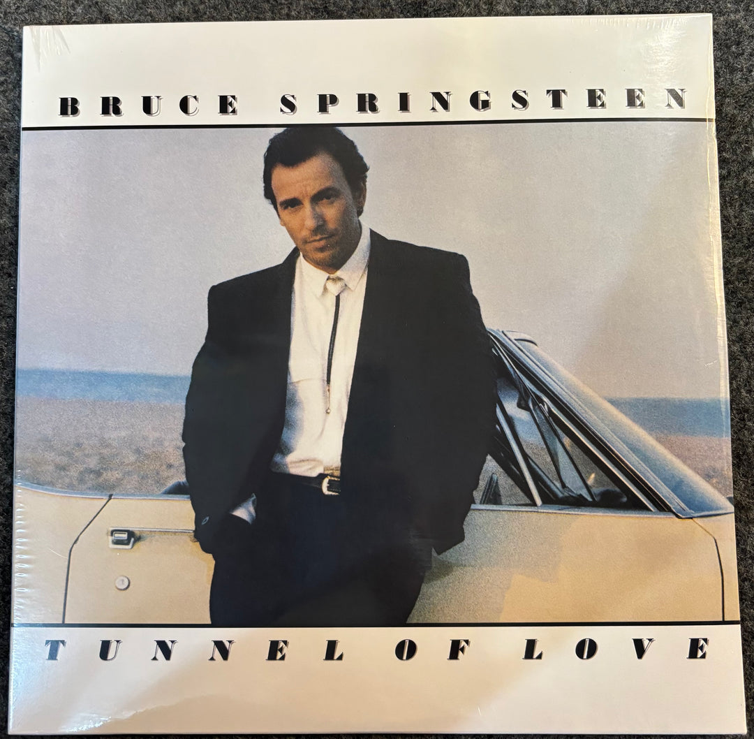 Album cover of 'Tunnel of Love' by Bruce Springsteen featuring a man in a suit leaning against a car.