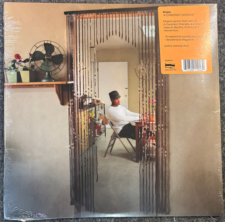 Elujay - A Constant Charade vinyl record sleeve, sealed in plastic. The cover features a photograph of a man sitting behind a beaded curtain, with an orange label in the top right corner containing track listing details.