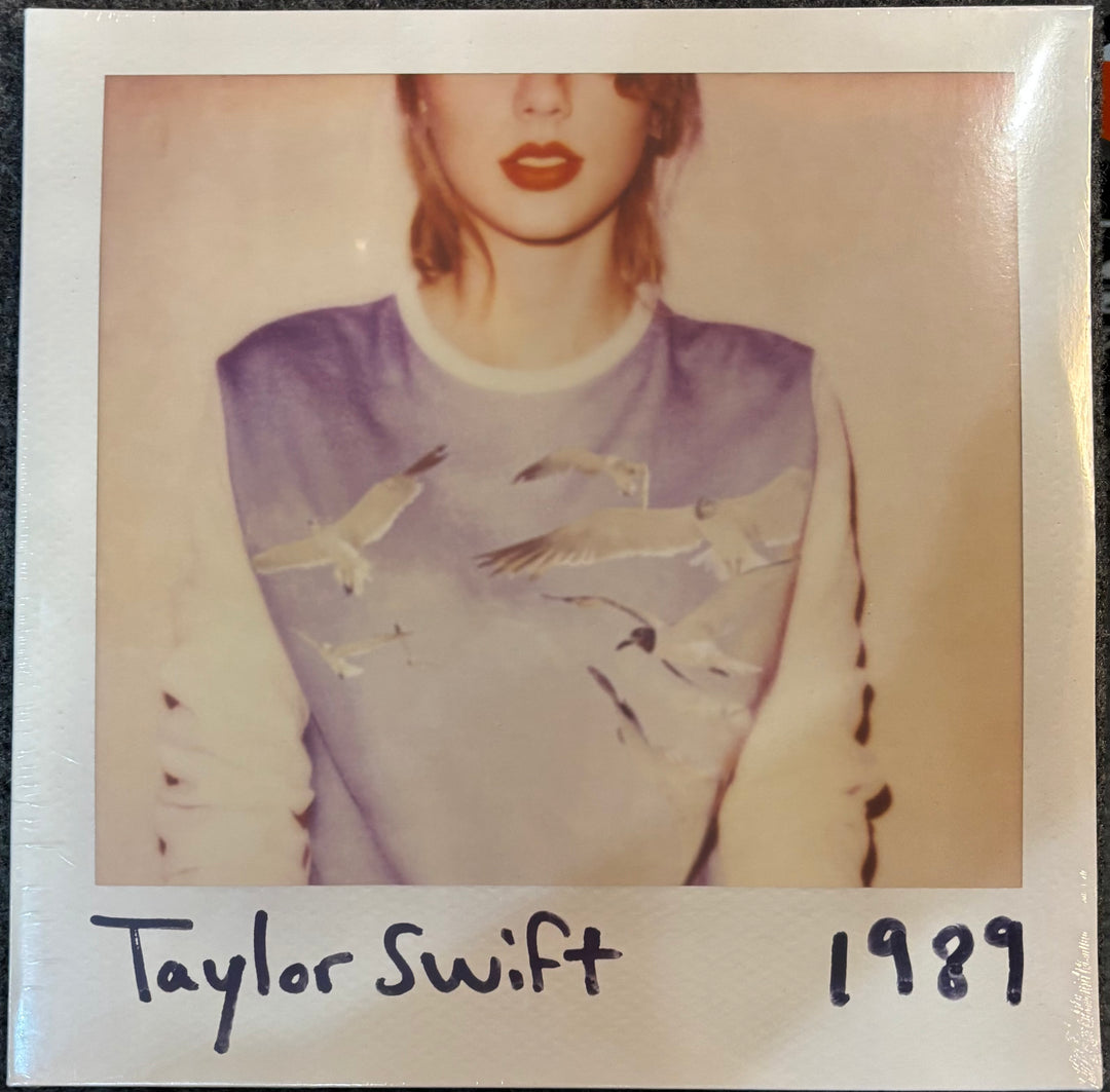 Album cover for '1989' by Taylor Swift with a Polaroid-style border.