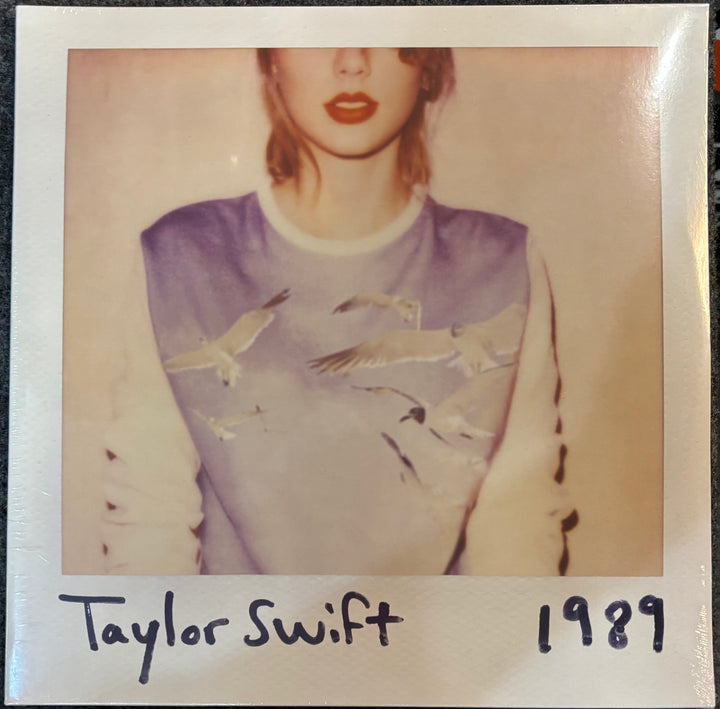 Album cover for '1989' by Taylor Swift with a Polaroid-style border.