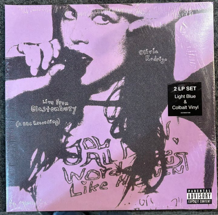 OLIVIA RODRIGO – LIVE FROM GLASTONBURY record cover with stylized text and a silhouette of a person, featuring a purple and black color scheme.