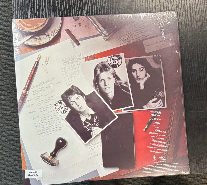 Paul McCartney & Wings – Band On The Run record cover with black and white photos of a band member on a textured surface