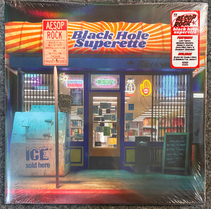 A sealed vinyl record sleeve for AESOP ROCK's 'Black Hole Superette', featuring a colorful, stylized storefront illustration with a prominent red and orange striped awning and a red 'AESOP ROCK' sign on the left.