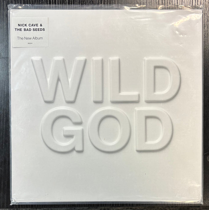 Album cover for 'Wild God' by Nick Cave & The Bad Seeds with embossed text on a white background.