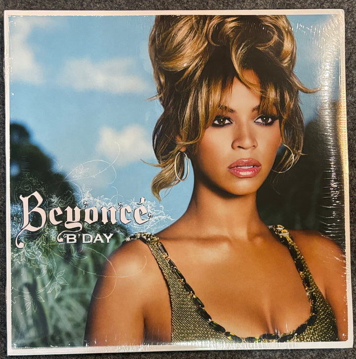 Beyonce '8' Day' vinyl record cover, sealed in plastic shrink wrap, displayed on a dark textured surface.