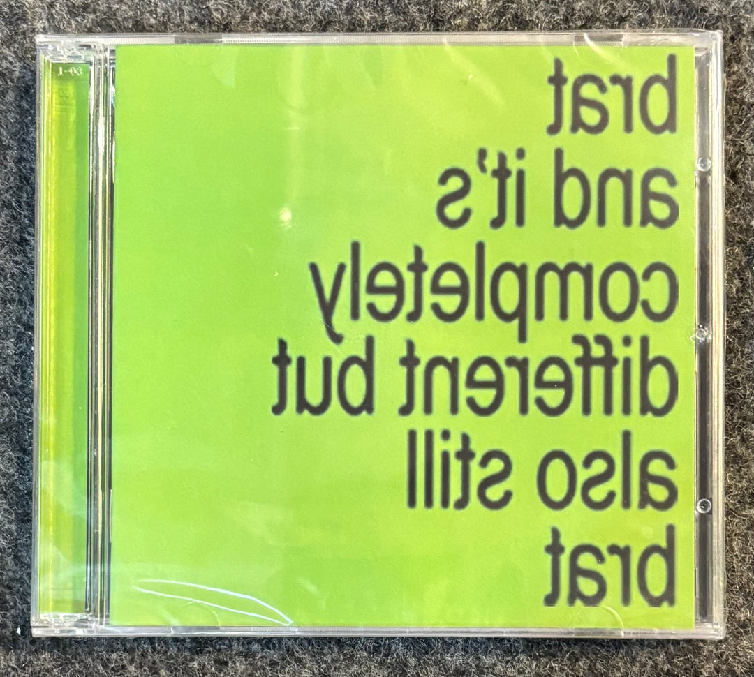 Charli XCX – Brat And It's Completely Different But Also Still Brat CD case with green cover and text on a textured surface