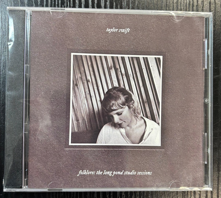 CD cover of 'folklore: The Long Pond Studio Sessions' by Taylor Swift with a black and white photo of the artist.